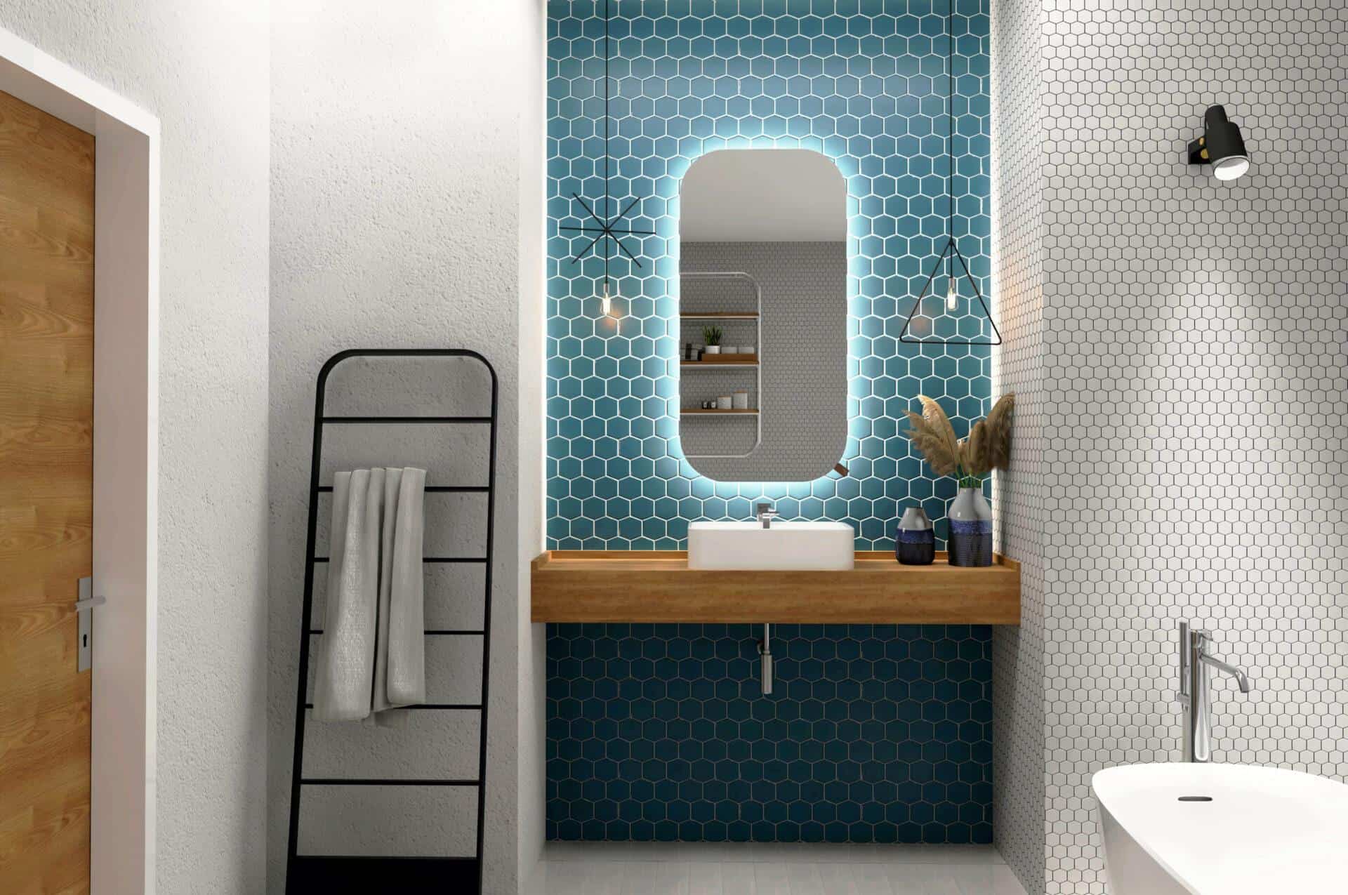 Nowoczesna łazienka z niebieską ścianą akcentującą z płytek heksagonalnych, PROSTOKAT_ZAOKRAGLONY_50X110_WYKADROWANY-1-skalowany-1.jpg podświetlane lustro, drewniany blat i umywalka, czarny wieszak na ręczniki, białe teksturowane ściany, lampy wiszące i rośliny na toalecie.